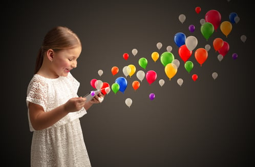 Cute little girl using tablet with colourful balloons concept