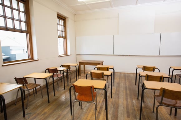 Empty classroom with empty chairs and desks