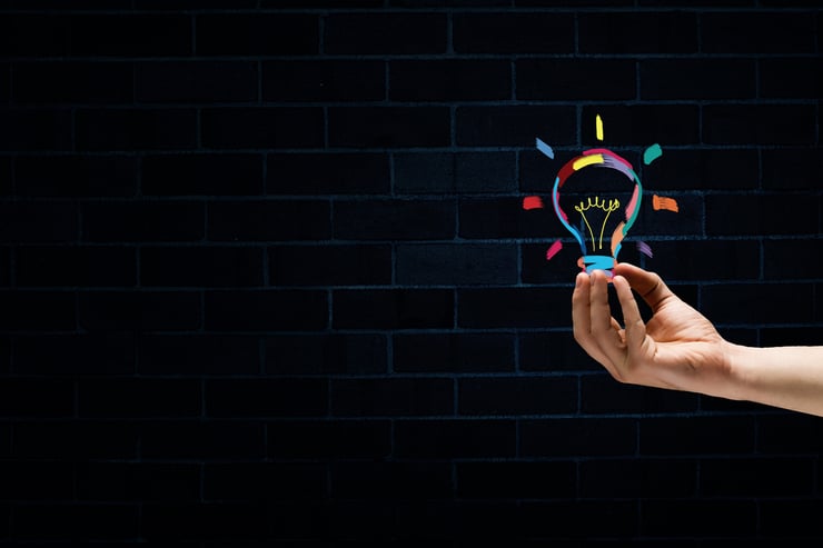 Male hand on dark background showing drawn light bulb-1