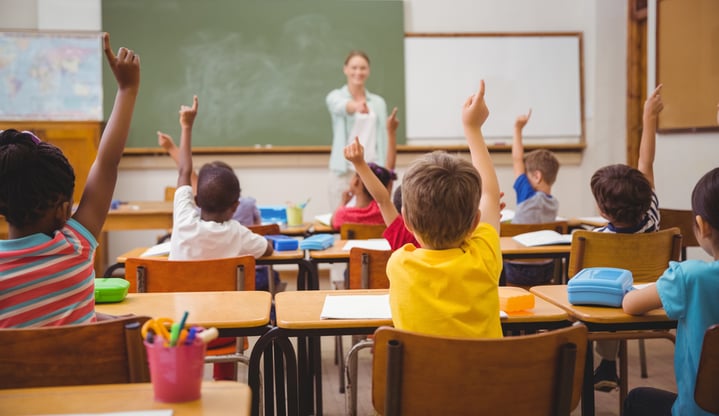 Pupils raising their hands during class at the elementary school-1