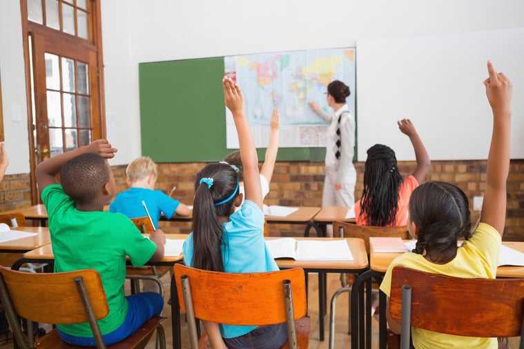 Teacher giving a geography lesson in classroom at the elementary school