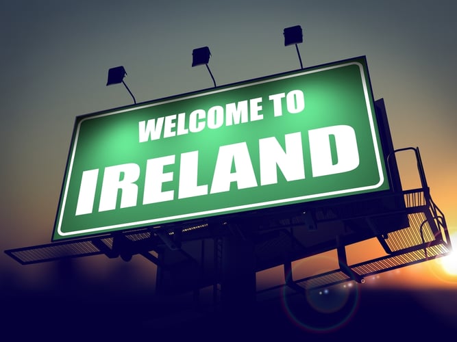 Welcome to Ireland - Green Billboard on the Rising Sun Background.